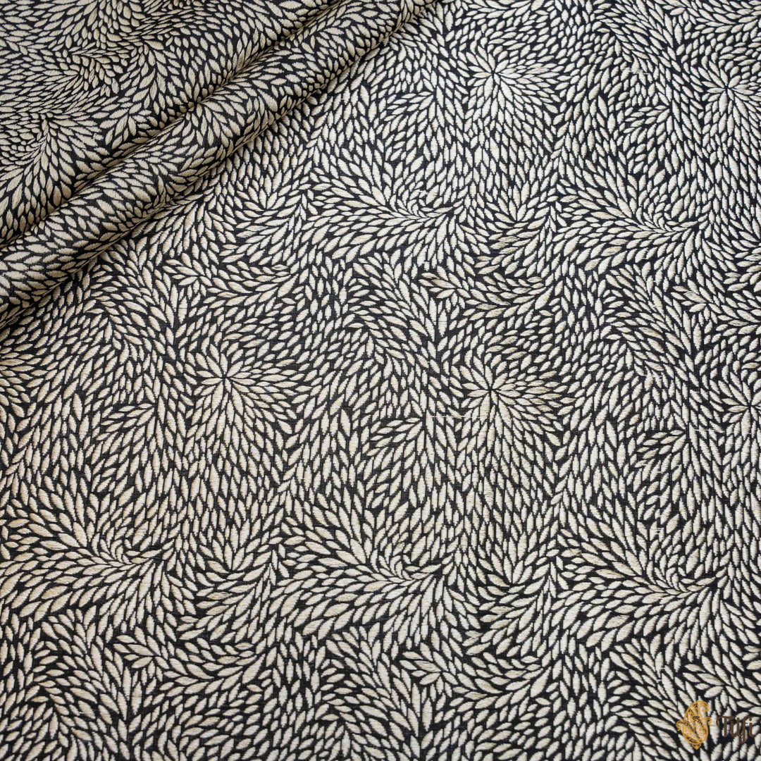 Elegant black Katan silk fabric with gold zari patterns, draped elegantly.