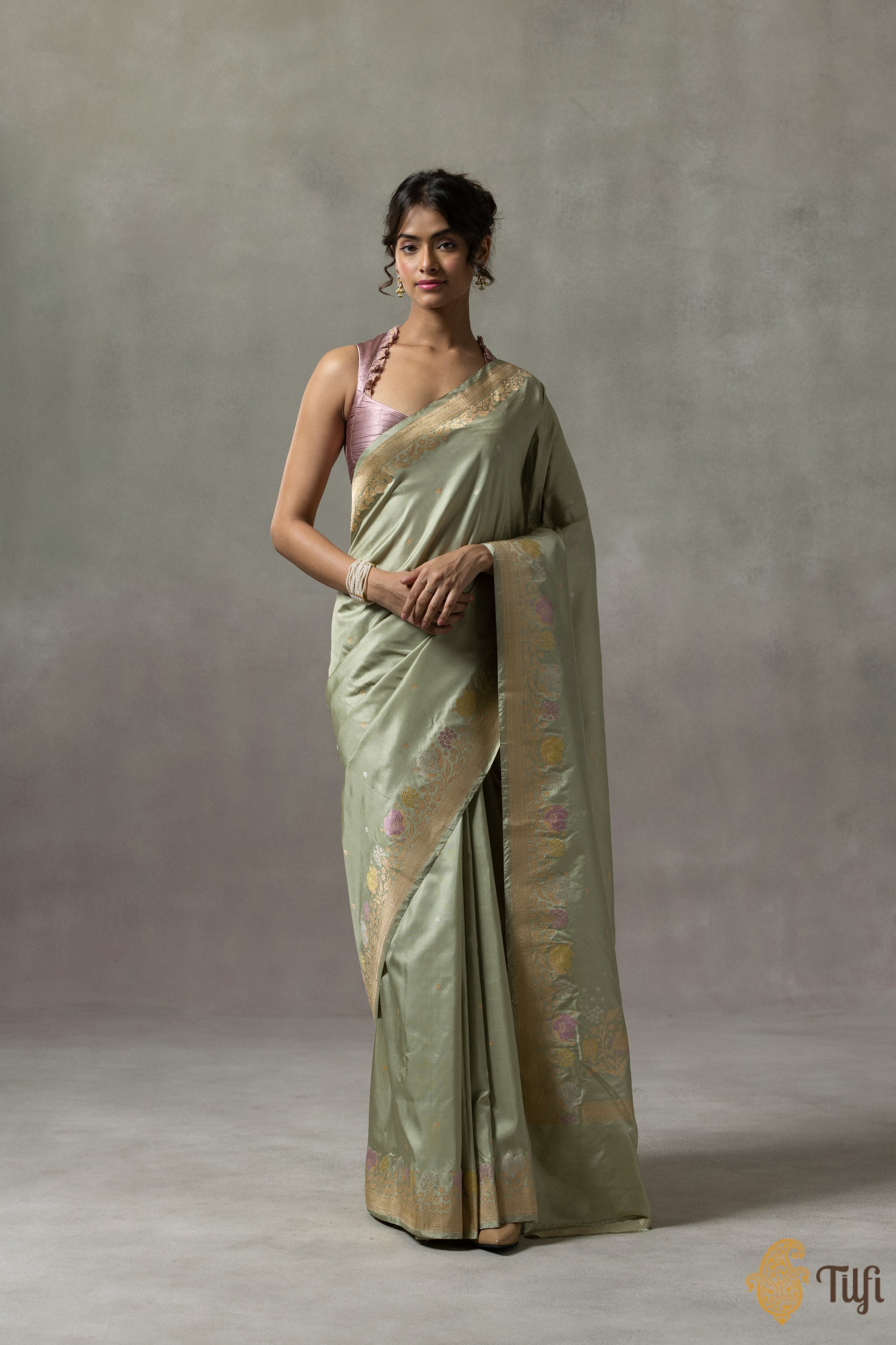 Close-up of intricate Meenakari border on pastel sage Banarasi saree