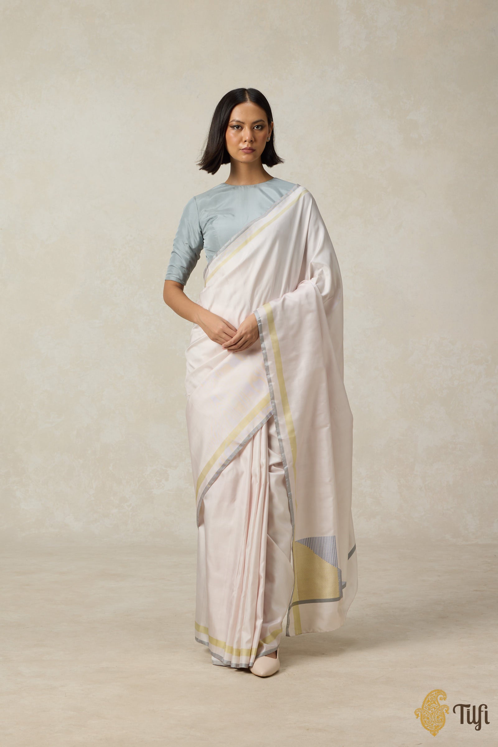 Close-up of the intricate twill weaving on a pink pure silk saree showcasing texture and sheen