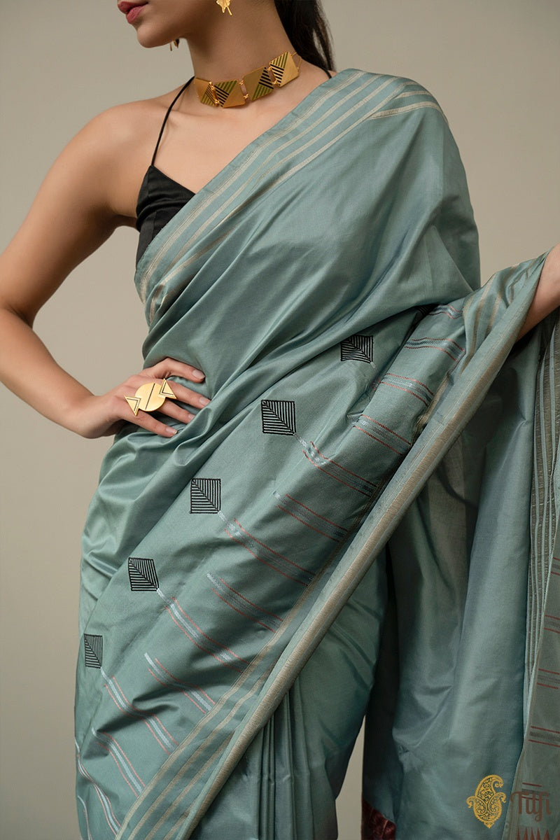 Dusty blue Banarasi saree draped on model, showing kite and triangle motifs