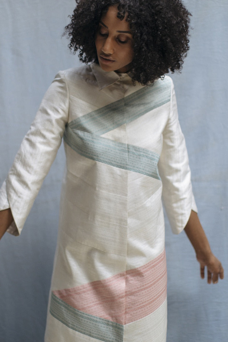 Close-up of off-white silk fabric with intricate handwoven pattern